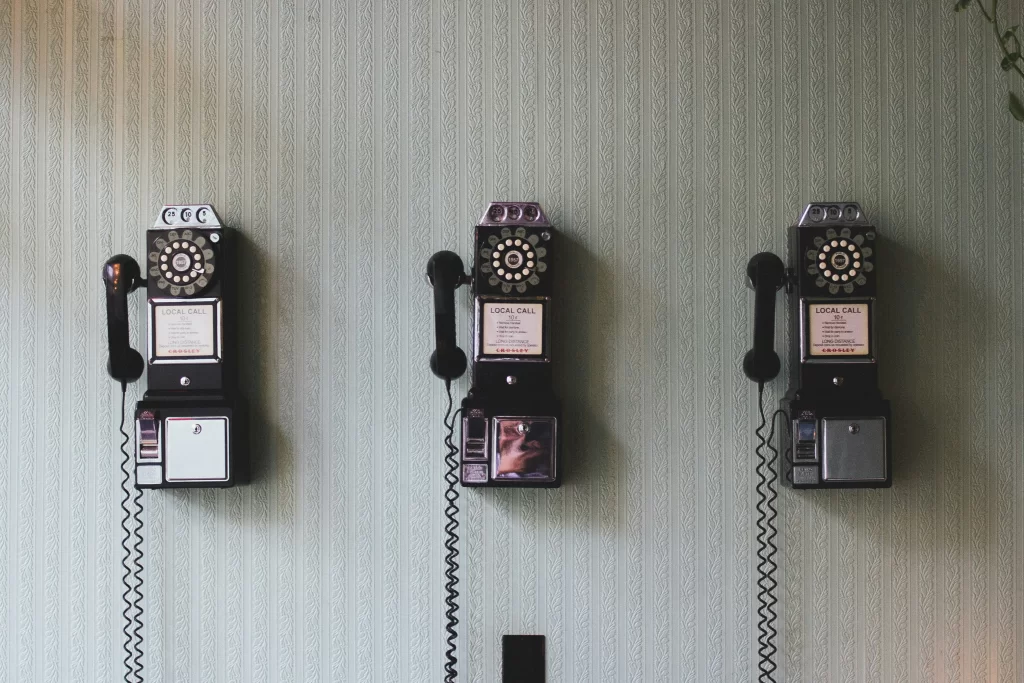 Vintage rotary telephones on a wall, symbolizing the evolution of communication technology and the shift towards digital transformation in modern times.