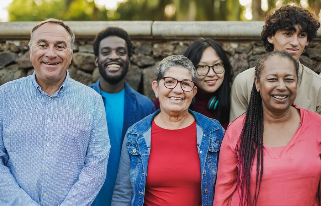 Multigenerational group of diverse people smiling outdoors, symbolizing an inclusive tech culture