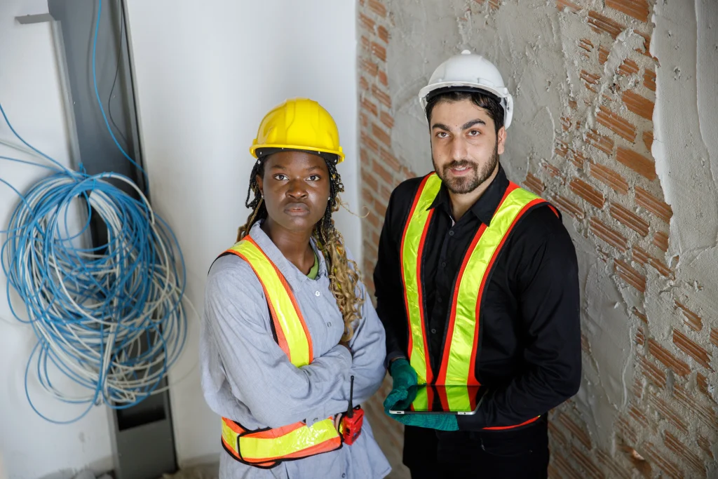 Two construction workers in yellow safety vests and hard hats, representing blue collar workforce solutions in Turkey.