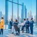 A cinematic, editorial-style image of a diverse group of professional businesspeople collaborating confidently in a sleek, modern office with iconic Dubai skyline and futuristic architecture visible through large windows, symbolizing seamless, innovative global hiring and investment in the UAE.