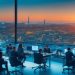A dynamic, cinematic scene of a modern office in Istanbul with diverse tech professionals collaborating over laptops and digital devices, set against a panoramic cityscape at dusk showcasing Turkey’s skyline, symbolizing innovation and vibrant growth in the local IT staffing and technology sector.